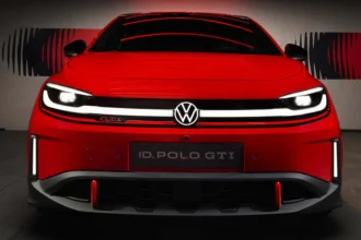 Современный электрический хэтчбек Volkswagen ID.3 заряжается на станции на фоне классической кареты с лошадьми.
