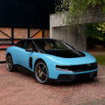 Роскошное электрическое купе Ferrari Luce ярко-красного цвета Rosso Corsa на фоне футуристичного небоскреба в Шанхае.