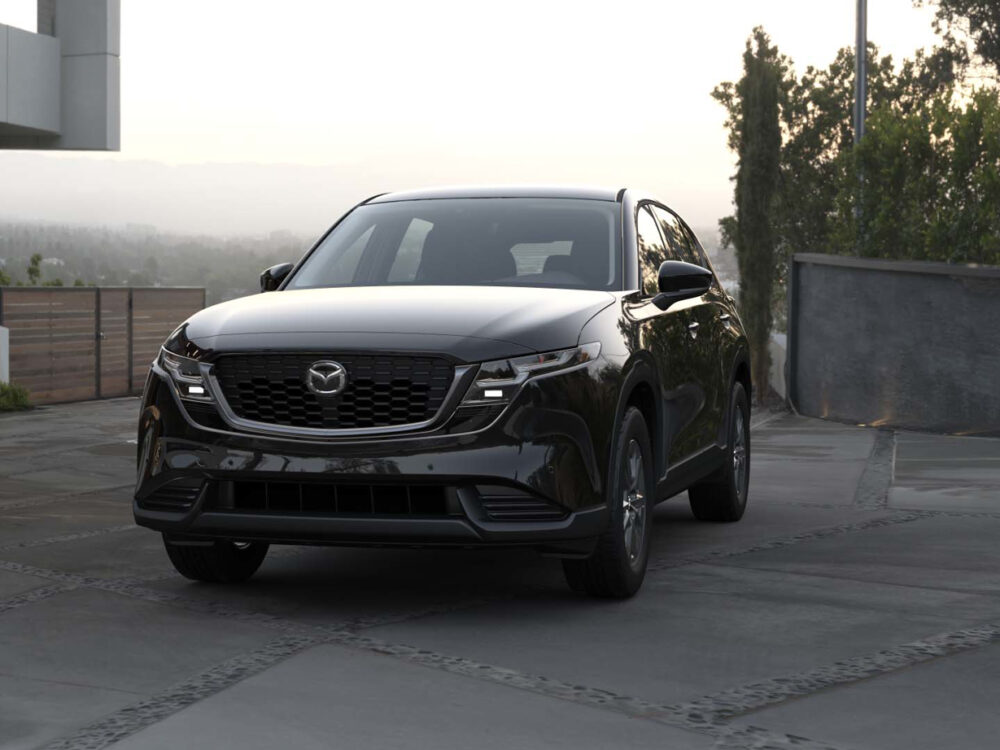 Стильный кроссовер Mazda CX-5 следующего поколения в фирменном красном цвете Soul Red на фоне горного серпантина.