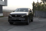 Стильный кроссовер Mazda CX-5 следующего поколения в фирменном красном цвете Soul Red на фоне горного серпантина.