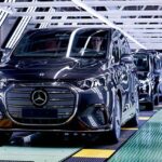 Роскошный электрический минивэн Mercedes-Benz VLE серебристого цвета выезжает из ворот завода в Испании.